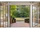 View of a lush backyard, as seen through French doors leading from the house to a covered patio area at 1355 Euclid Ne Ave # 15A, Atlanta, GA 30307