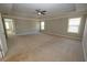 Spacious bedroom with tray ceiling, ceiling fan, plush carpeting, and multiple windows providing ample natural light at 2034 W Hampton Dr, Canton, GA 30115