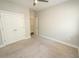 Bedroom featuring neutral walls and carpet, ceiling fan, and closet doors with ample storage space at 2034 W Hampton Dr, Canton, GA 30115