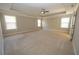 Spacious bedroom features three bright windows, neutral walls and carpet, and a ceiling fan at 2034 W Hampton Dr, Canton, GA 30115
