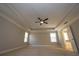 Inviting bedroom with a tray ceiling, ceiling fan, large windows, and an en-suite bathroom entrance for convenience and privacy at 2034 W Hampton Dr, Canton, GA 30115