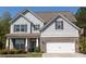 Beautiful two-story home with gray siding, brick accents, and a two-car garage. Includes a basketball hoop on the side of the driveway at 2034 W Hampton Dr, Canton, GA 30115