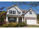 Charming two-story home featuring a brick-accented garage, gray siding, and a well-manicured front yard with mature landscaping at 2034 W Hampton Dr, Canton, GA 30115