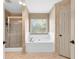 Bathroom with a shower and a bath beneath a window with blinds at 2424 Malden Park Dr, Buford, GA 30519
