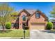 Two story brick home features manicured lawn, two car garage, and mature landscaping at 2424 Malden Park Dr, Buford, GA 30519