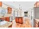 Open kitchen with an island, granite countertops, stainless steel appliances, and hardwood floors at 2424 Malden Park Dr, Buford, GA 30519