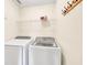 Bright laundry room with washer, dryer, wire shelving, and coat hooks on the wall at 2424 Malden Park Dr, Buford, GA 30519