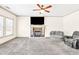 Bright living room has a ceiling fan, fireplace, and neutral carpet at 2424 Malden Park Dr, Buford, GA 30519
