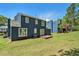 Backyard featuring a well-maintained lawn and a wooden deck, framed by a two-story navy blue house at 3455 Kingsbrooke Way, Decatur, GA 30034