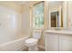 Bathroom with a tub-shower combo, toilet, and vanity with mirror, all illuminated by a window at 3455 Kingsbrooke Way, Decatur, GA 30034
