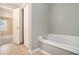 Bathroom showcasing a relaxing bathtub, complemented by tiled floors and a view into the bedroom at 3455 Kingsbrooke Way, Decatur, GA 30034
