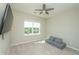 Bedroom with large wall-mounted TV, window, and comfortable gray lounge seating at 3495 Delegate Aly, Scottdale, GA 30079