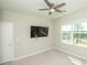 Bedroom features a ceiling fan, large TV, and a window with a nice neighborhood view at 3495 Delegate Aly, Scottdale, GA 30079