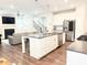 Open kitchen and living area with a spacious island, stainless steel appliances, and a fireplace at 3495 Delegate Aly, Scottdale, GA 30079