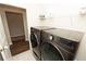 Laundry room with a new pair of gray washer and dryer and shelving at 3495 Delegate Aly, Scottdale, GA 30079