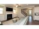 Cozy living room with a fireplace, built-in shelves, and open staircase, adjacent to kitchen at 3495 Delegate Aly, Scottdale, GA 30079