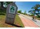 A cyclist rides along Stone Mountain PATH trail beside an informational trail marker on a clear day at 3495 Delegate Aly, Scottdale, GA 30079