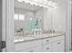 Bright bathroom features double vanity, granite countertop, and a large, framed mirror at 74 Academy St, Alpharetta, GA 30009