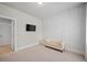 Bedroom with neutral color carpet, herringbone accent wall, a mounted TV, and a small beige bench at 74 Academy St, Alpharetta, GA 30009