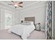 The bedroom features neutral walls and carpet, with white bedding and gray tufted headboard at 74 Academy St, Alpharetta, GA 30009