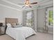 Bedroom with ceiling fan, tray ceiling, neutral walls and carpet, and patterned drapes and headboard at 74 Academy St, Alpharetta, GA 30009