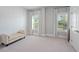 Carpeted bedroom featuring herringbone accent wall, dual windows with natural light, and a small bench at 74 Academy St, Alpharetta, GA 30009
