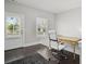 Bright office with a modern chair, desk, dark wood floors, and view to outside through the door and window at 74 Academy St, Alpharetta, GA 30009