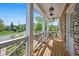 Relaxing covered porch with brick accent wall, hanging lanterns, and a view of the landscaped yard and street at 74 Academy St, Alpharetta, GA 30009