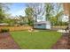 Landscaped backyard with manicured lawn, fire pit, wooden fence and detached garage at 2374 Marion Cir, Decatur, GA 30032