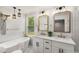 Bathroom with double vanity, framed mirrors, and freestanding tub under pendant lights at 2374 Marion Cir, Decatur, GA 30032