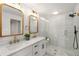 Bright bathroom featuring double vanity, framed mirrors, and glass enclosed shower at 2374 Marion Cir, Decatur, GA 30032