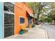Unique orange building with sidewalk bench, potted plants, and colorful awnings adding charm to the street at 2374 Marion Cir, Decatur, GA 30032
