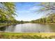 Calm lake surrounded by lush greenery and a clear blue sky at 2374 Marion Cir, Decatur, GA 30032