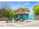 Bright blue coffee shop exterior with tiled roof, sidewalk seating, and street visibility, surrounded by trees at 2374 Marion Cir, Decatur, GA 30032