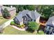Aerial view of the brick home with well-maintained lawn, colorful flower beds, and mature trees in a suburban setting at 3237 Birkdale Ave, Duluth, GA 30097