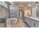 An expansive bathroom featuring a freestanding tub, double vanity, walk-in shower, and gray wood-look tile flooring at 3237 Birkdale Ave, Duluth, GA 30097