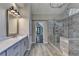 Modern bathroom featuring a glass enclosed shower, dual sink vanity with stone countertops, and gray wood-look tile flooring at 3237 Birkdale Ave, Duluth, GA 30097