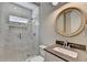 Modern bathroom with marble tile shower, vanity with granite countertop, and round mirror at 3237 Birkdale Ave, Duluth, GA 30097
