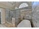 Modern bathroom showcasing a glass shower and standalone tub, lit by a arched window at 3237 Birkdale Ave, Duluth, GA 30097