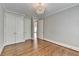 Bedroom features hardwood floors, closet space, neutral paint, and elegant chandelier at 3237 Birkdale Ave, Duluth, GA 30097
