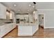 Well-lit kitchen boasts white cabinets, stainless steel appliances, granite counters, and hardwood floors at 3237 Birkdale Ave, Duluth, GA 30097