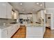 Bright kitchen boasts white cabinets, stainless steel appliances, granite countertops, and hardwood floors at 3237 Birkdale Ave, Duluth, GA 30097