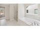Bathroom with a tub, walk-in shower, tile floor and exterior view at 5827 Creek Indian Dr, Sugar Hill, GA 30518