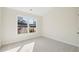 Cozy carpeted bedroom with a large window and view of the residential neighborhood at 5827 Creek Indian Dr, Sugar Hill, GA 30518