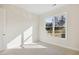 A carpeted bedroom with a window offering natural light and views of the outdoor landscape at 5827 Creek Indian Dr, Sugar Hill, GA 30518
