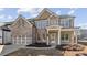 Charming brick two-story home with a two-car garage and covered entryway at 5827 Creek Indian Dr, Sugar Hill, GA 30518