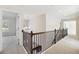 Upstairs hallway features a decorative railing and plush carpeting at 5827 Creek Indian Dr, Sugar Hill, GA 30518