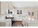 Bright kitchen features white cabinets, stainless steel appliances, an island, and hardwood floors at 5827 Creek Indian Dr, Sugar Hill, GA 30518