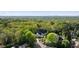 An aerial shot shows the house surrounded by lush trees with a city skyline visible in the distance at 725 Riley Pl, Atlanta, GA 30327