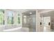 Bathroom featuring a modern tub, a glass-enclosed shower, and a view of the surrounding trees at 725 Riley Pl, Atlanta, GA 30327